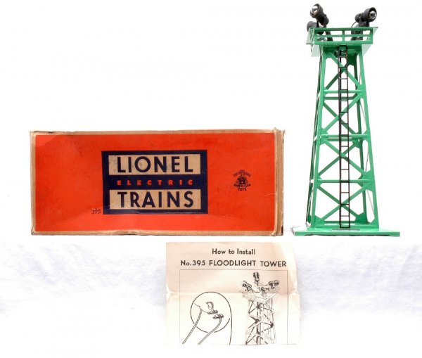 Lionel 395 Green Floodlight Tower LN Boxed: Lionel postwar 395 green floodlight tower with instruction sheet in OB. The tower is C8. The OB has one interior flap detached and there is some edge wear.