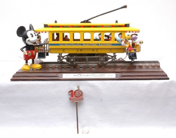 Pride Lines Walt Disney Electric Railway Trolley: Pride Lines Walt Disney Productions electric railway trolley with a wooden display board that has a Walt Disney World Tencennial 1971-1981 plaque. The trolley is C8. Mickey MouseÕs hand has broken of