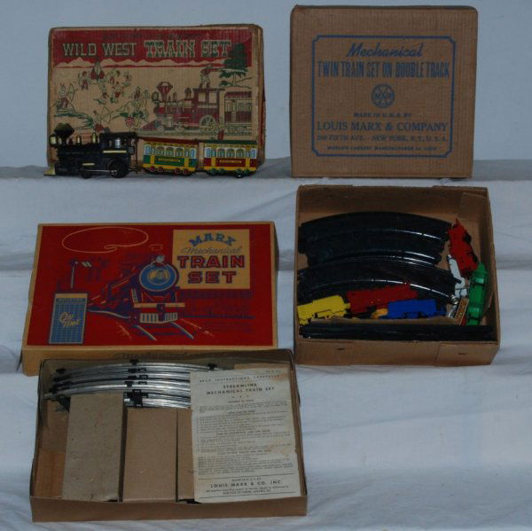 Three Marx sets 2065, 518, and un- numbered: Three Marx sets. Includes 516 Steam Freight with all inserts, instructions and track. Missing windup key. Condition is OB has hole in top. C7-8. 2065 Twin train set includes track, windup key both red