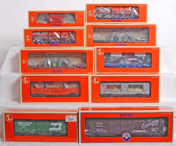 10 modern Lionel cars, wells, LRRC, mint, etc.: 10 Lionel Modern freight cars in OBs. Lot includes two well cars, 16983 Pennsylvania and 16946 Chesapeake and Ohio. 17553 Trailer Train Ford flatcar with frames, 26872 Animated Pony express gondola, 1
