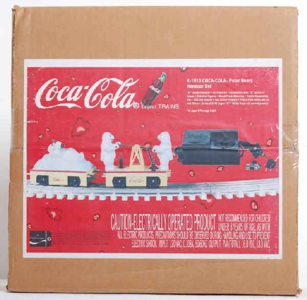 K Line sealed Coca Cola handcar set: K Line K-1913 Coca Cola hand car set sealed in OB. OB has some slight ink loss on the upper corner of the label, and set number written in marker on one end. Set includes hand car, trailer, circle of
