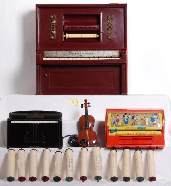 Four toy musical toys/instruments, Magnus Organ: Magnus Organ, #151 Magnus Harmonica Co. in working order. J. Chein and Son, Piano Lodeon with a broken key, twelve musical rolls. 1971 Kenner Walt Disney sing along jukebox. A plastic violin. Please v
