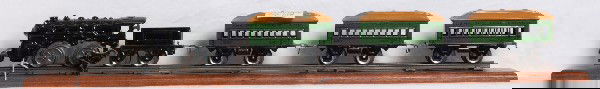 The Joy Line cast iron mechanical w/three 357: Prewar O gauge The Joy Line cast iron mechanical key wind locomotive and tinplate tender with three No. 357 The Joy Line Coach passenger cars. One passenger car has some surface rust on one side of fr