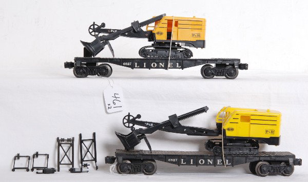 Two Lionel 6827 flatcars w/shovels dark & light: Postwar O gauge Lionel No. 6827 flatcars with P&H power shovels, light and dark yellow cabs. Flatcars look C7-8. Shovels have trim missing tabs and pieces.