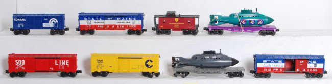 8 Lionel freight cars 16724, 04039, 9740, etc.: Lionel modern O Gauge freight cars. Eight cars includes 16724 Disney sub car, 04039 Navy sub car, 9740 Chessie boxcar, 6464-275 modern LLC State of Maine boxcar, 9709 State of Maine boxcar, 9207 Soo b