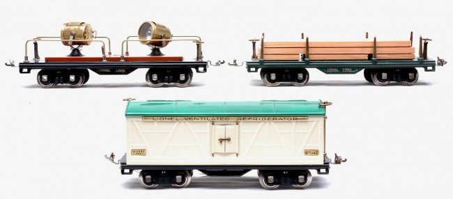 Lionel Prewar Std. Ga. Freights 511 514 520: Lionel prewar standard gauge 511 dark green flatcar with wood load, 514 ivory refrigerator car and a 520 terra cotta searchlight car. The cars all have brass trim and nickel journals. Cars have been p