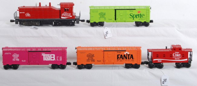 Lionel Coke train, 8473, 9743, 9744, 9745, 9073: Modern era Lionel Coke Train with No. 8473 Coke NW-2 diesel switcher with 9473 Sprite boxcar, 9744 Tab boxcar, 9745 Fanta boxcar, and 9073 Coke caboose. Trains look C7, loco has C5-6 frame/chassis wit