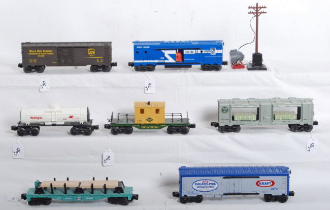 Lionel 19486, 9879, 9321, 6400, 19825, 9036, 6420: Modern era Lionel O gauge freight cars, 19486 NYC flatcar with lumber, 9879 Kraft Philadelphia Cream Cheese reefer, 9321 Bureau of Engraving and Printing Mint car, 6400 UPS boxcar, 19825 GM EMD operat
