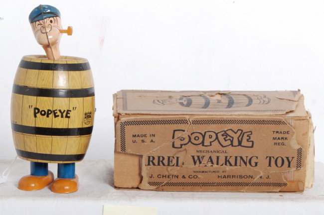 J. Chein Popeye mechanical barrel walking toy in O: J. Chein & Co. Popeye mechanical barrel walking toy in partial original box. Box has been taped to a cardboard sleeve. Toy looks C7-8. Mechanism winds and operates.