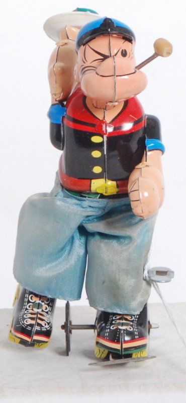 Linemar roller skating Popeye windup tin toy: Linemar roller skating Popeye windup tin toy. Toy winds up but functions sporadically. Small hole in pants. Toy otherwise looks C7-8.