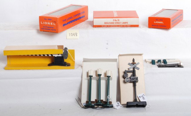 Lionel No. 140, 252, 3 No. 76, in OB Mint: Postwar Lionel O gauge No. 140 banjo signal with components and w/insert, No. 252 crossing gate with components and w/insert, and 3 No. 76 boulevard street lamps with insert/warranty card. Accessories
