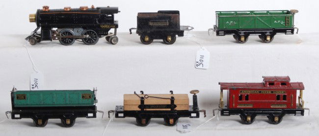 American Flyer tinplate O gauge loco and freight: Prewar American Flyer O gauge unnumbered tinplate steam loco and tender with 3013 sand car, 3009 dump car, 3006 lumber car with load and restraints, and 3014 caboose. Loco has casting fatigue to wheel