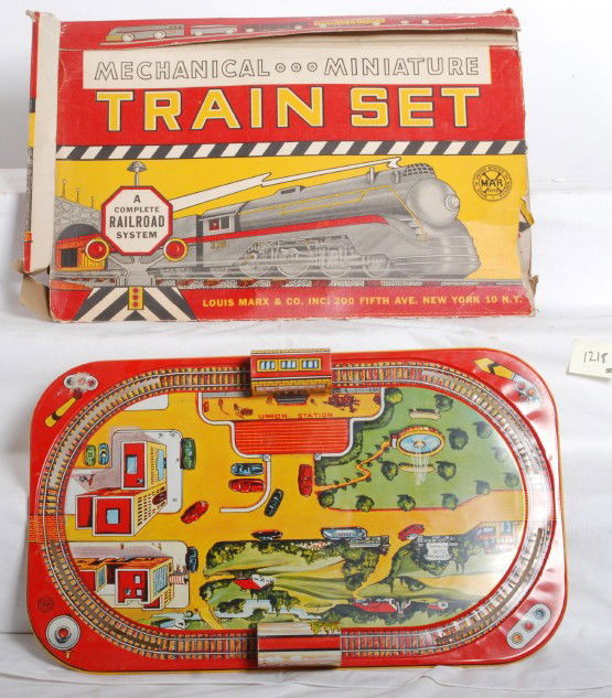 Marx tin mechanical train set: Marx tin toy modern train set with original box. Original box is missing one end flap and another is partially torn. Trains are missing, but layout is C7 with some scratches and play wear. The layout