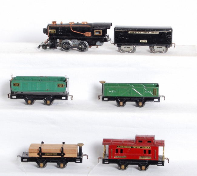 American Flyer steam loco and freight cars: Prewar American Flyer O gauge tinplate electrical steam locomotive and tinplate No. 1121 tender, 3009 dumping car, 3013 sand car, 3006 flatcar with lumber load and original load restraints, and 3014 c