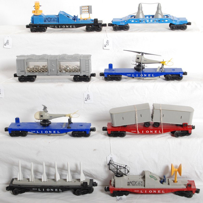 Lionel 6844, 6413, 3540, 3545, 6445, 6440, 3419 x2: Postwar Lionel O gauge 6844 flatcar w/missiles, 6413 Mercury capsule car, 3540 radar car, 3545 TV car, 6445 Fort Knox car, 6440 flatcar w/trailer vans, and two 3419 helicopter launching flatcars. Trai