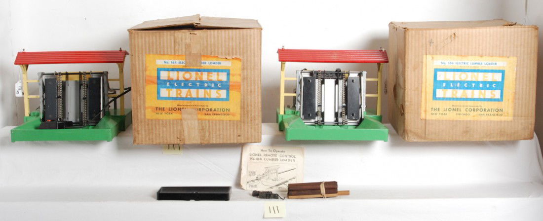 Two Lionel No. 164 electric lumber loaders in OB: Postwar Lionel O gauge No. 164 electric lumber loaders in original boxes with controllers. Both look C6-7. One box is C8 area. Other is C8 in shape with two pencil sized punctures in a side panel and