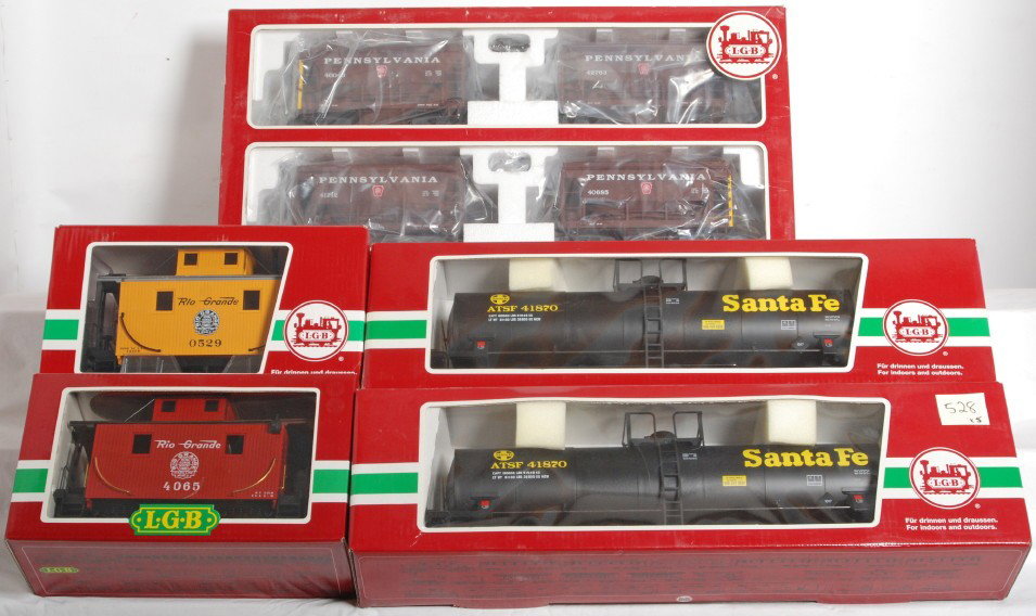 Lot of LGB G scale freight cars in original boxes: Modern era LGB G scale 40040 Pennsylvania ore cars w/loads, two 41870 Santa Fe tanks, 4065 Rio Grande bobber caboose, and 45650 Rio Grande bobber caboose. Trains look C9-10. Boxes show very little to