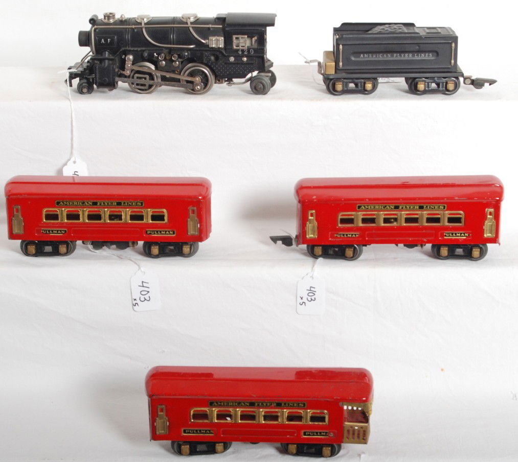 American Flyer 420 loco, tender, red passenger car: Prewar American Flyer O gauge No. 420 die cast steam loco, tinplate tender, two Pullmans and an observation car. Trains look very nice C6++. Loco has a chipped pilot wheel.