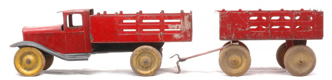 Wyandotte Red Stake Truck w/Red Trailer: Wyandotte pressed steel red stake truck with black fenders that is 9 1/2 inches in length and a red trailer that is 5 3/8 inches in length both with wooden wheels. The truck and trailer are both C5.