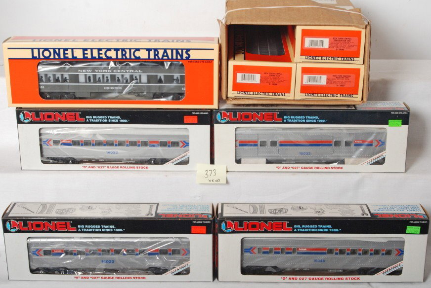 8 Amtrak and NYC cars 16033, 16089: Lionel modern O gauge passenger cars in OBs, eight cars total. Amtrak cars include two 16023 coaches, 16033 baggage, and 16048 diner. New York Central cars include 16087 baggage, 16088 coach, 16089 di