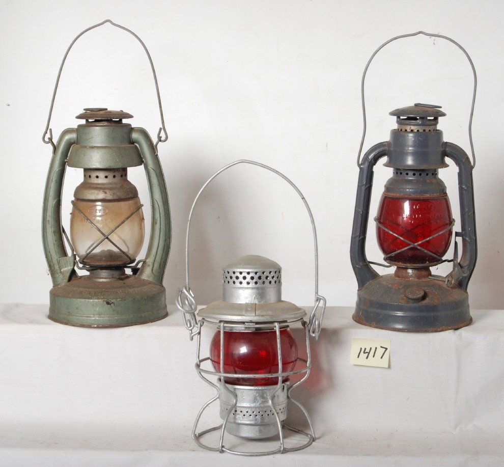 3 Adlake and Dietz lanterns: Three Adlake and Dietz lanterns. Adlake lantern is stamped with Penn Central logo on top, other two Dietz lanterns have no railroad markings. Lanterns have some light rust. See photos for best descrip