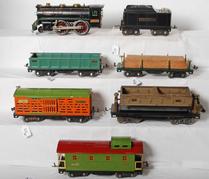 Lionel S.G. 384-E, 384-T, 511, 512, 513, 517, 218: Prewar Lionel standard gauge 384 steam locomotive and 384-T tender with 511 flatcar with lumber load, 512 gondola, 513 stockcar, 517 caboose, and a 218 dump car. Loco has been rewheeled. Trains look C