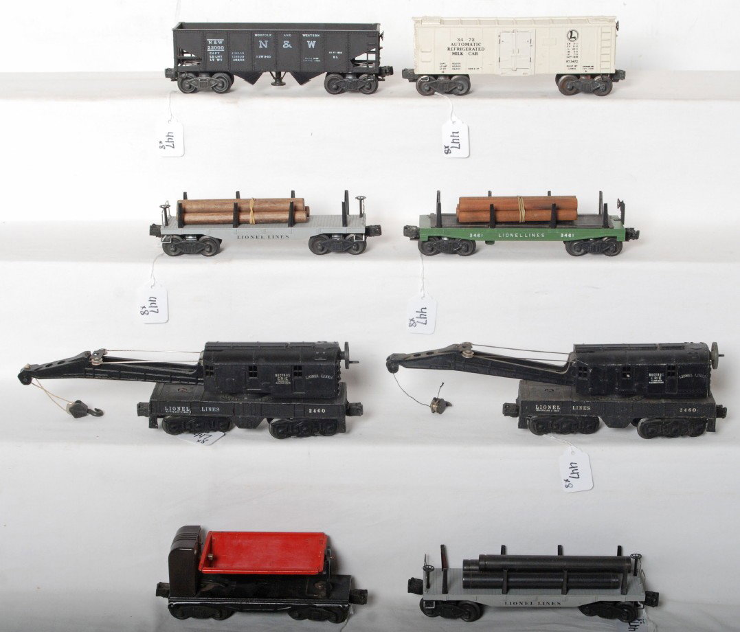 Lionel 3559, 3461, 2411, 2411, 2460, 2460, 3472, 3: Postwar Lionel O gauge freight cars, 3559 operating coal dump car (mechanism cover is odder brown Bakelite variation with hairlines), 3461 operating log car, two 2411 flatcars (one with pipes, other h