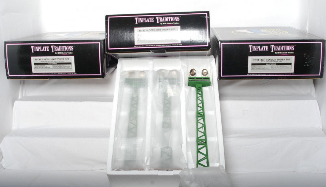 3 MTH No. 92 floodlight tower sets: MTH modern standard gauge tinplate 1044 No. 92 floodlight tower sets in OBs. Three sets of three in OBs. Towers are C8-9 condition. OBs have light corner and edge wear.