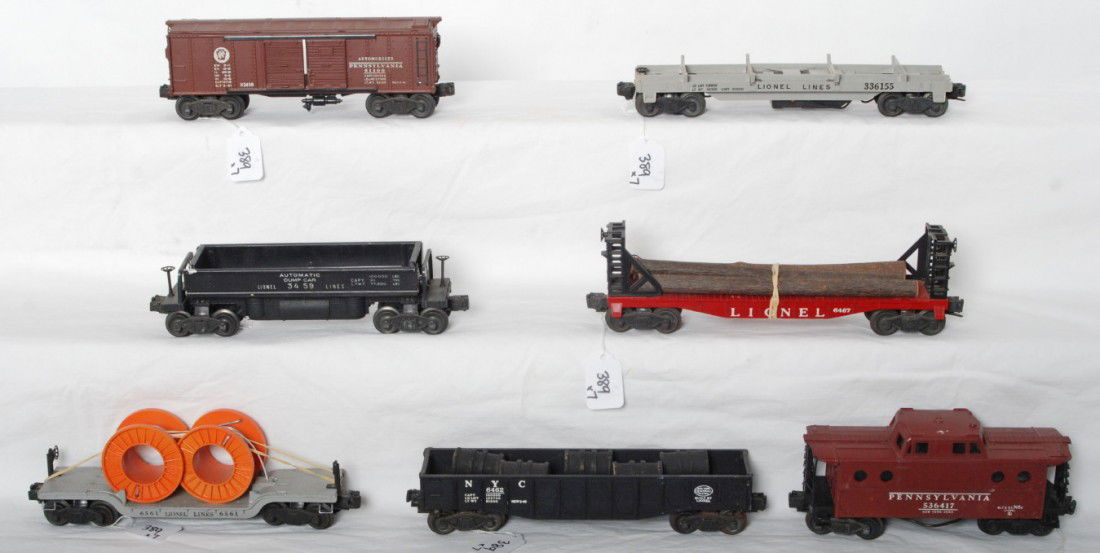 Lionel 3459, 3361, 6462, 6561, 6467, 2458, 6417: Postwar Lionel O gauge 3459 automatic dump car, 3361 lumber car, 6462 New York Central gondola, 6561 cable reel car, 6467 miscellaneous car, X2458 Pennsylvania double door automobiles car, and 6417 Pe