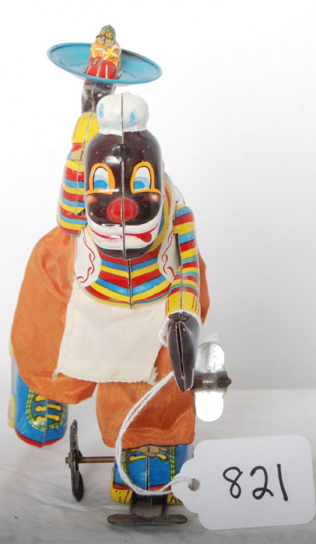 Black roller skater waiter with fruit tray, mechan: Lithographed tinplate windup mechanical toy of a black waiter on roller skates carrying a serving tray with a plate of fruit, C8+. T.P.S. trade mark Japan.