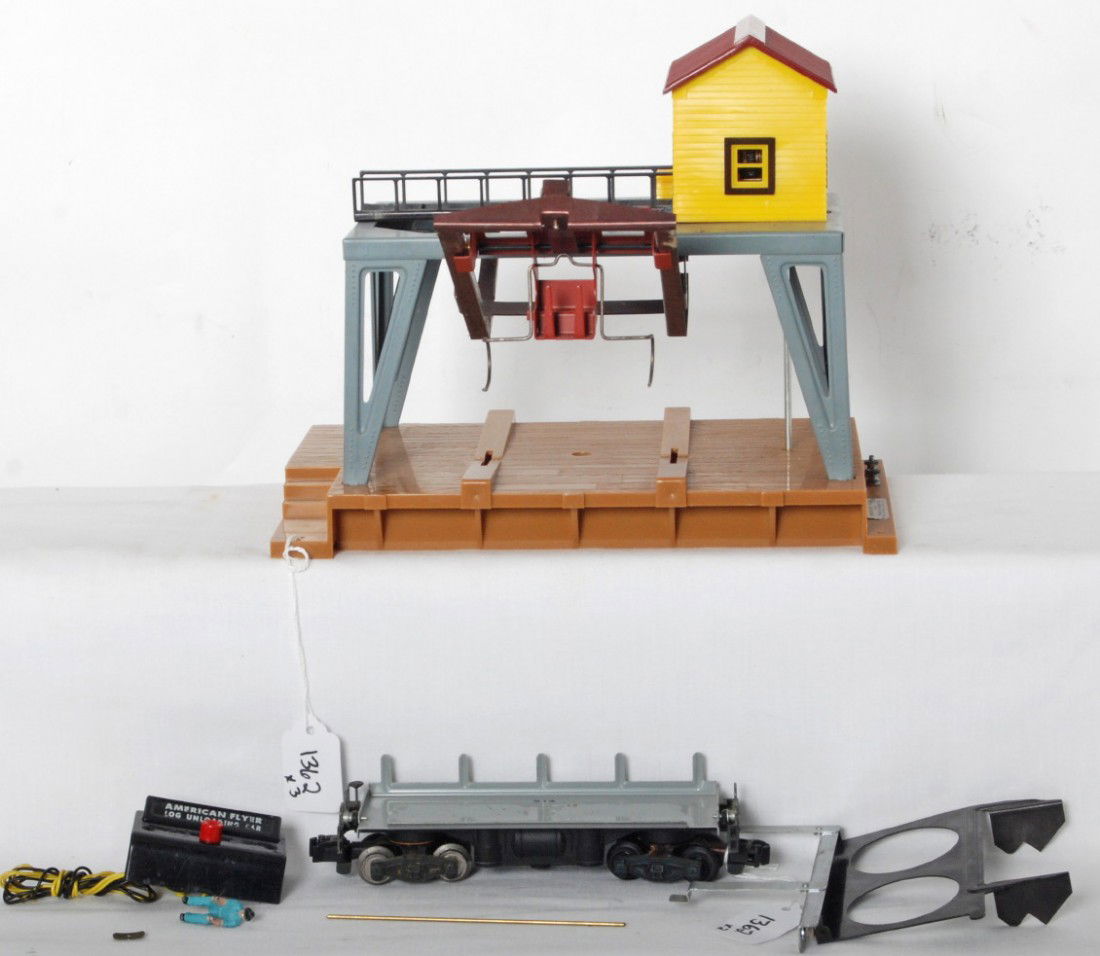 American Flyer operating log loader and 914 unloa: Postwar American Flyer S gauge operating log loader accessory with detached parts from underneath base. 914 unloading car with gray painted tray, track contact rail and controller. Accessory and car l