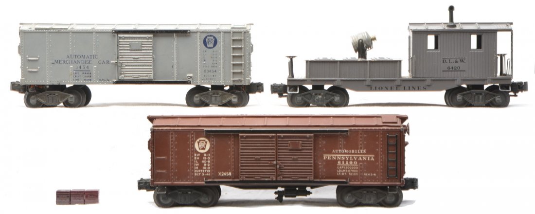 Lionel 3454 PRR 2458 Auto Car 6420 DL&W: Lionel postwar freight cars; 3454 operating Pennsylvania merchandise car with blue lettering and three Baby Ruth cubes, 2458 Pennsylvania automobile car and a 6420 D.L.&W. dark gray work caboose. Cars