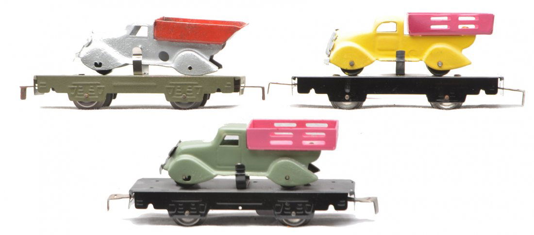 Marx 4-Wheels 2-562 Flats w/Stake Trucks Dump: Marx four wheel two 562 black flatcars with stake trucks, one restored with yellow truck and pink bed and one with a sage green truck and pink bed. The flatcars have been repainted. Also included is a