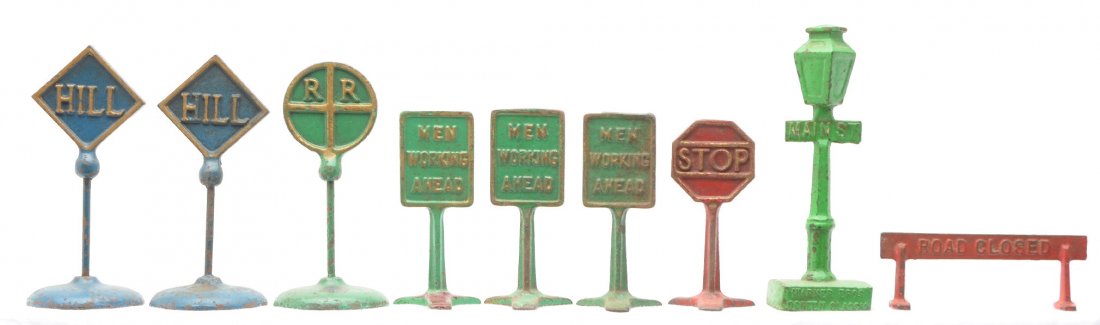 Arcade Cast Iron RR HILL and Misc. Signs: Arcade cast iron signs, one green with R R and two blue with HILL. Also included are a selection of cast iron signs including; a WARNER BROS. SCREEN CLASSICS MAIN ST. street light, three green MEN WOR