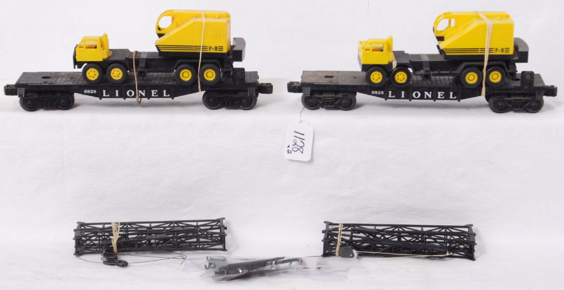 Two Lionel 6828 flatcars w/truck cranes: Postwar Lionel O gauge 6828 flatcars with truck cranes. Both flatcars look unrun. One looks C8 area, other needs cleaned. Cranes are sold as is.