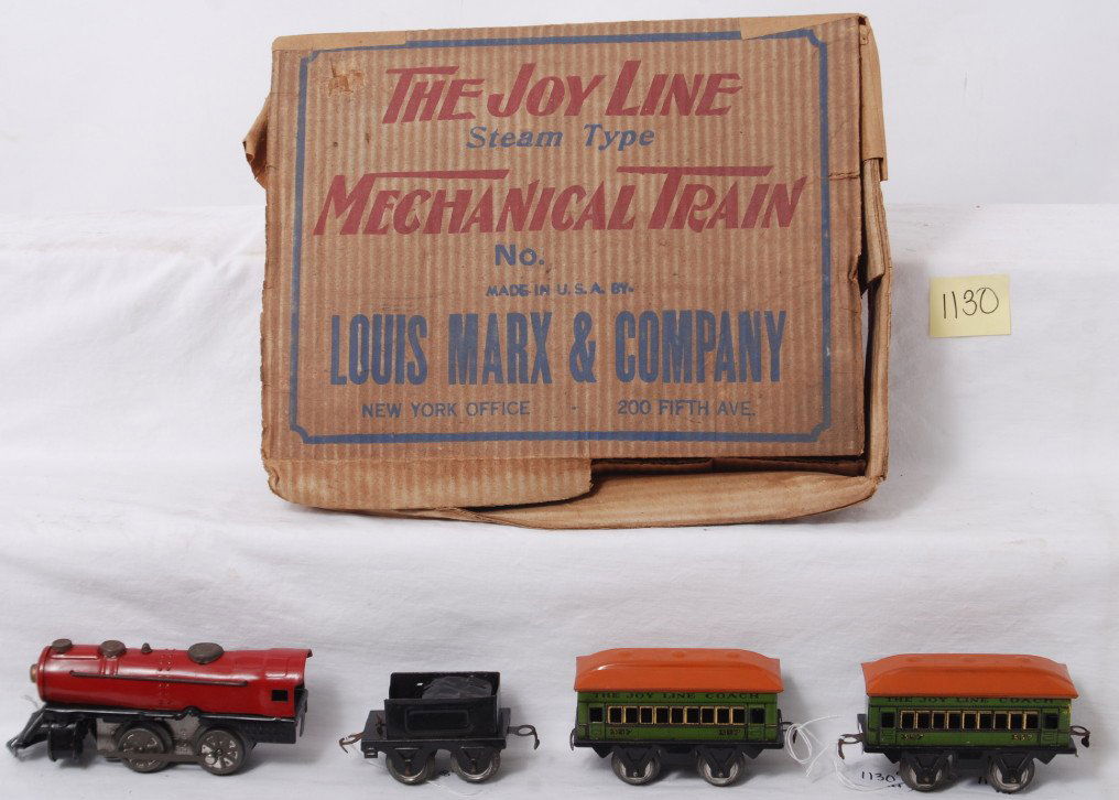 Marx The Joy Line steam type mechanical train set: Marx O gauge The Joy Line steam type mechanical train in original box. Set is comprised of: undecorated red and black tinplate windup mechanical loco and all black tinplate tender with two lithographe