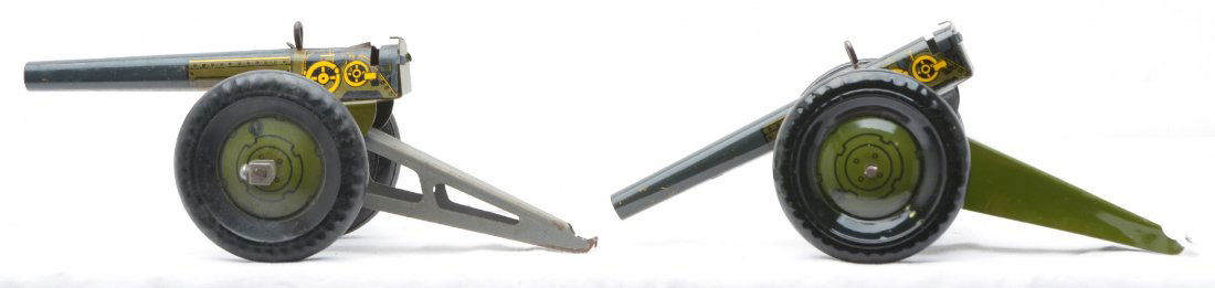 Marx two Tin Lithographed Anti-Aircraft Guns: Marx two tin lithographed anti-aircraft guns with spring loading mechanisms Both of the guns have black wheels with olive drab centers. The structure on one of the guns appears to have had the paint s