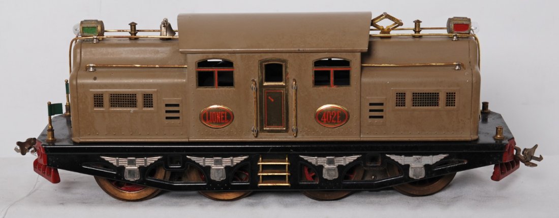 Lionel 402E center cab electric Lt. Mohave: Prewar Lionel standard gauge 402E center cab electric locomotive, loco should clean C6-7. Very light casting fatigue to headlights. Light Mohave with red lettering on brass plates.