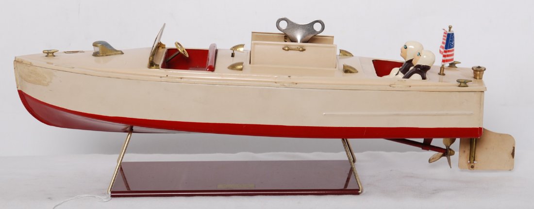 Lionel 43 speed boat w/stand, drivers, and key: Prewar Lionel 43 speed boat with touchups/repainting, C7 area. Key appears to be original. Reproduction stand, drivers, and flag.