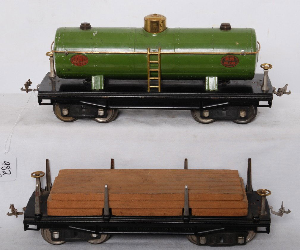 Lionel 211 flatcar and 215 oil car: Prewar Lionel standard gauge 211 flatcar with lumber load missing one stake, and 215 oil tank car, C6 area.