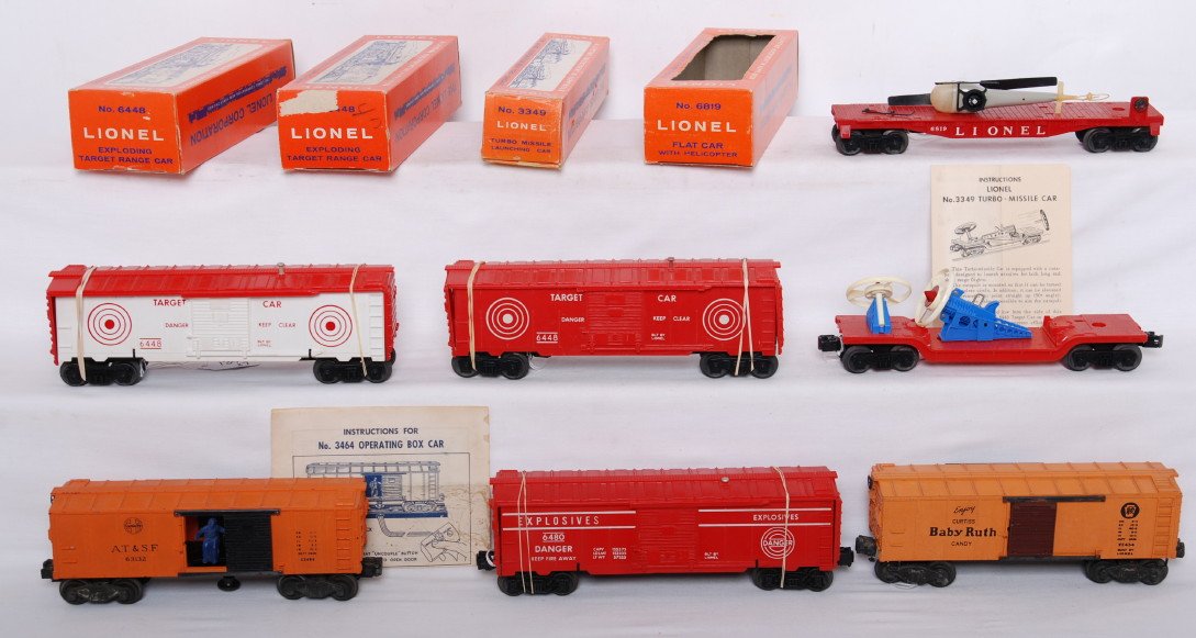 Lionel 6448, 6448, 6480, 3349, 6819, 3464, 2454: Postwar Lionel O gauge two 6448 exploding target range car, 6480 explosives boxcar, 6819 flatcar w/helicopter, 3349 turbo missile launcher, 3464 A.T.S.F. operating boxcar, and 2454 PRR Baby Ruth boxca