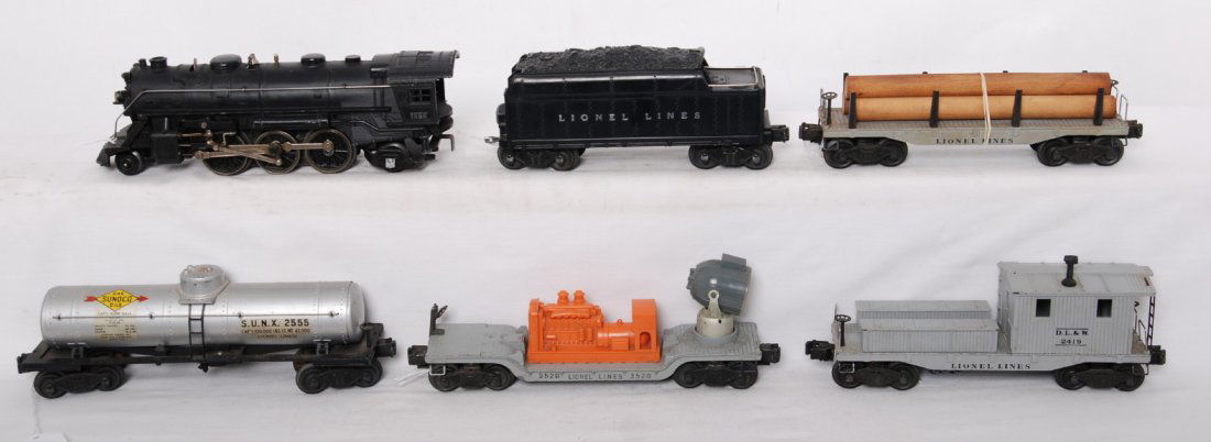 Lionel 1666, 2466WX, 2555, 2411, 3520, 2419: Postwar Lionel O gauge 1666 steam locomotive, 2466WX whistle tender, 2555 Sunoco tank, 2411 lumber car, 3520 searchlight car (brake wheel is missing rivet, someone has cleverly used a nail), and 2419