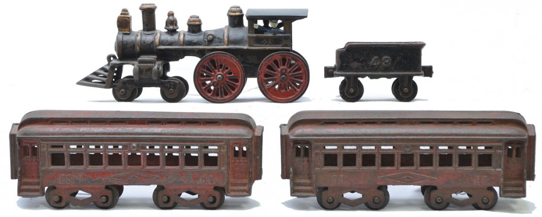 Jones & Bixler Cast Iron Floor Toy Train Set: Jones & Bixler cast iron floor toy train set, circa 1909-10 including; steam loco numbered 49, tender numbered 48 and two red coaches numbered 88. The coaches are usually blue. The red version is unus