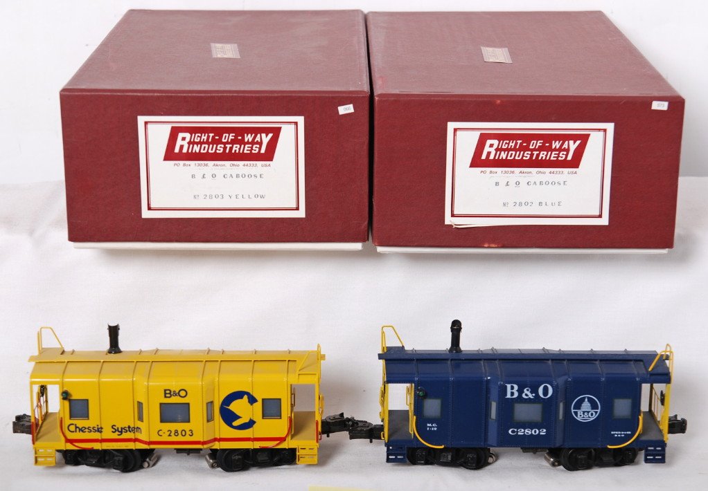 2 Right of Way B&O brass cabooses: RIght of Way modern brass O gauge Baltimore and Ohio cabooses in OBs. Includes 2802 B&O blue and 2803 B&O / Chessie System yellow. C8-9 with faint roller and wheel marks.