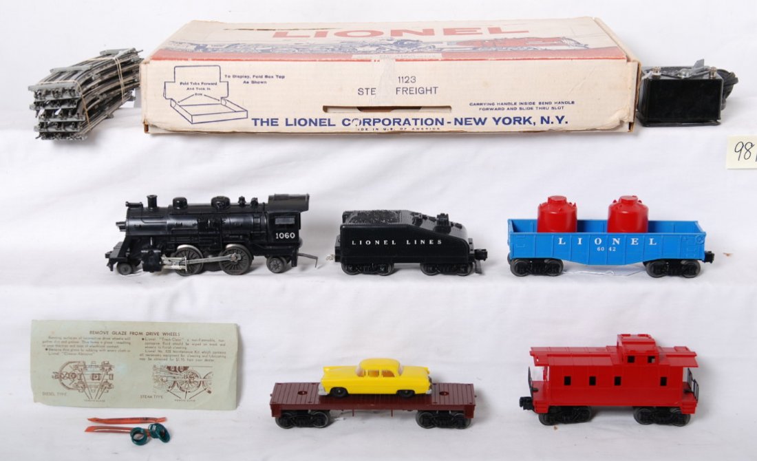 Lionel 1123 steam freight with headlight, 1060...: Postwar Lionel O gauge 1123 steam freight set in original box, 1060 steam loco and slopeback tender, 6042 canister car, unnumbered flat with auto, and undecorated caboose, C8-9. Track, transformer, an