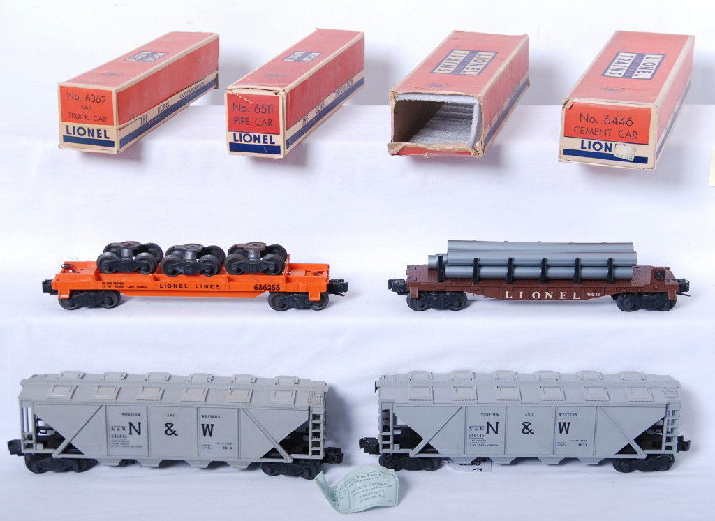 Lionel 6511, 6362, 6446, 6446 in OB: Postwar Lionel O gauge 6511 pipe car, 6362 rail truck (unrun), 6446 N&W cement car and 6446 N&W cement car (unrun with inspection slip), trains C7-9. Loads on 6362 have light surface rust. Boxes have