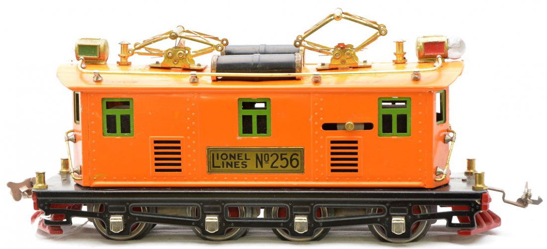 Lionel 256 Orange Electric Loco w/Brass Plate: Lionel prewar O gauge 256 orange electric 0-4-4-0 electric loco with brass plate. The roof on the loco is dented in the middle and one side is bowed out due to the dent. The paint on the loco cab is v