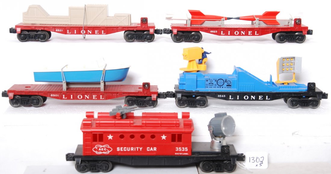 Lionel 6801, 6821, 6823, 3545, and 3535: Postwar Lionel O gauge 6801 flatcar w/boat, 6821 flatcar w/freight load, 6823 flatcar w/rockets, 3545 T.V. car, and 3535 AEC security car, cannon on top is missing a barrel. Trains look C7-8, some car