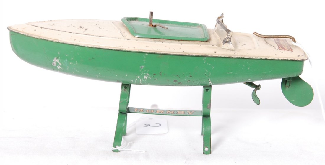 Hornby Speedboat Hawk tinplate boat w/stand: Postwar Hornby Speedboat, ÒHawkÓ. Tinplate boat with approximately 80% paint, dinged starboard stern corner, C6. Missing key. Propeller is missing a blade. Motor feels as though tension increases, p