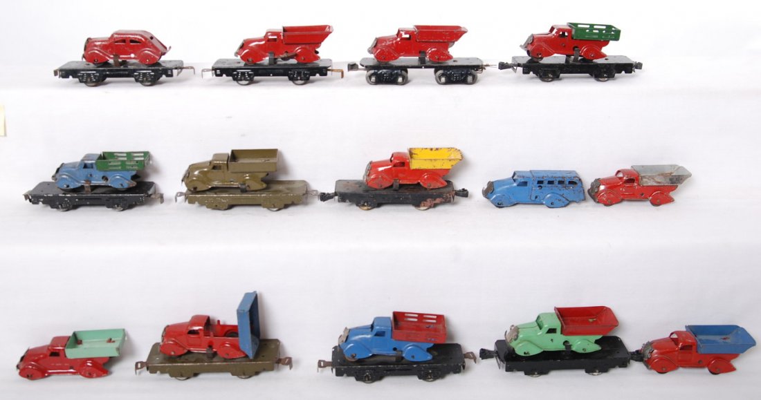 Postwar/prewar Marx O gauge flats w/trucks, auto, & loo: Prewar/postwar Marx O gauge flatcars with trucks and one with an auto. Ten flats total with four extra trucks and a bus. Items range C5 to C7 area.